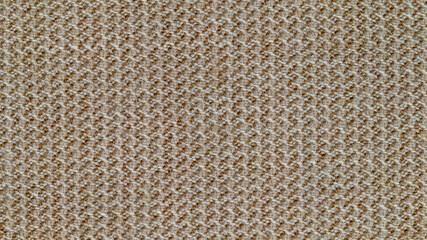 Close-up photo of fabric texture for use as background. The fabric is made from a mixture of orange and gray threads. A mixture of synthetics and wool. Abstract pattern.