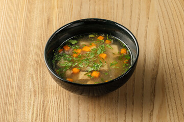 A warm bowl of soup served with fresh ingredients, offering comfort and hearty flavor.