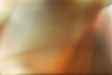 Soft grainy light leak texture background with warm brown, orange, and beige gradient, vintage film...