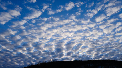 Dramatyczne białe chmury na niebieskim porannym niebie
