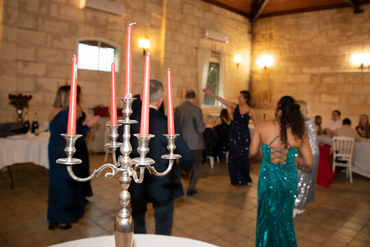 silver candelabra centerpiece at a lively party with guests dancing in formal attire at night