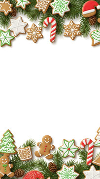 Festive Christmas border made of decorated gingerbread cookies and fir branches on a white background.