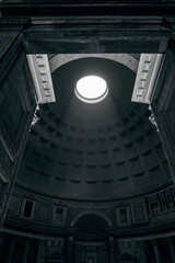 Light streams through the Pantheon oculus illuminating the coffered dome and ancient interior...