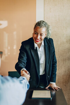 Smiling female lawyer doing handshake with businessman during legal deal in office