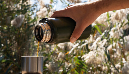 Camping Concept: Fresh Coffee Being Poured on a Sunny Day