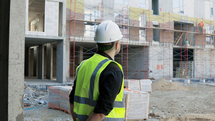 A construction worker is observing the building site
