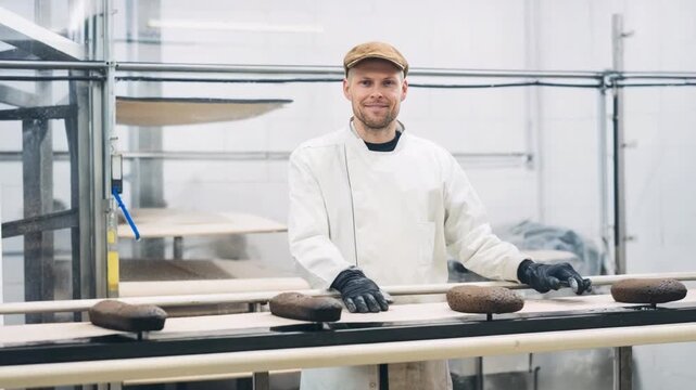 The Baker's Embrace: A baker, radiating warmth and expertise, stands proudly in a clean, modern bakery, his gaze fixed confidently on the viewer, amidst the baking process.