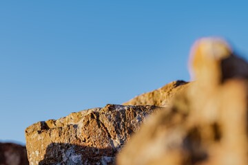 3d presentation pedestal or dais made of rock illuminated by sunlight. 3d rendering of mockup of presentation podium for display or advertising purposes