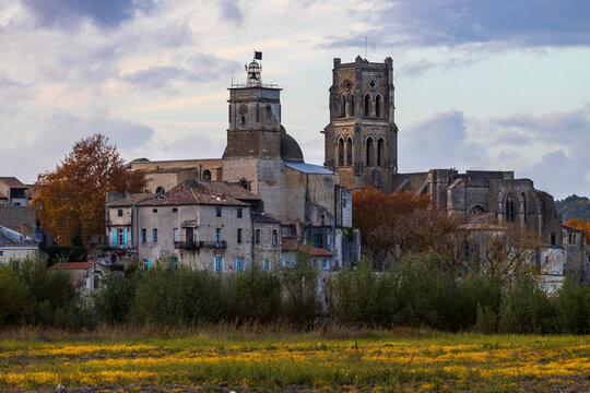 City of Pont-Saint-Esprit with its churches Saint-Saturnin and Saint-Pierre seen from the left bank of the Rhône at sunset