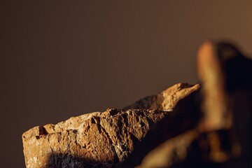 3d presentation pedestal or dais made of rock illuminated by sunlight. 3d rendering of mockup of presentation podium for display or advertising purposes