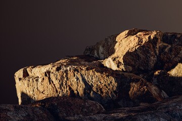 3d presentation pedestal or dais made of rock illuminated by sunlight. 3d rendering of mockup of presentation podium for display or advertising purposes