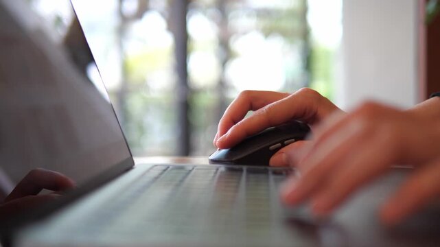 Hand Using Wireless Mouse While Working on Laptop &ndash; Remote Work and Productivity Concept