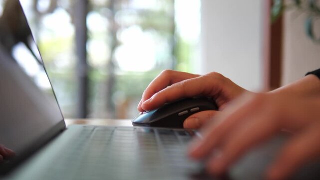 Hand Using Wireless Mouse While Working on Laptop &ndash; Remote Work and Productivity Concept