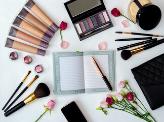 Cosmetics and accessories arranged on a white surface.