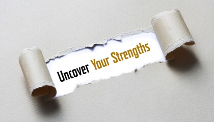 Inspirational "Uncover Your Strengths" Message Revealed Through Textured Light Grey Torn Paper; Ideal for human resources portals, talent acquisition blogs, and career development workshops.