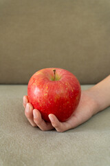 A child's hand holding a red apple