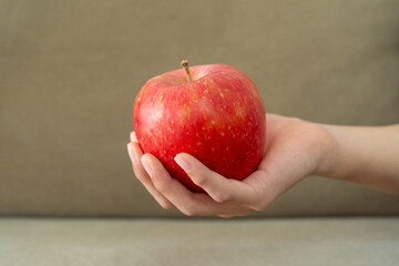 赤いリンゴを持った子どもの手