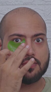 Vertical Video of Man Applying Patch Under the Eyes