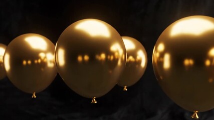 Array of gold balloons floating in dramatic dark lighting