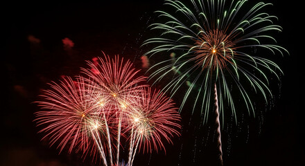 Array of red and green firework bursts against dark night sky, symbolic of celebration, festivity and festive occasions like New Year or national holiday