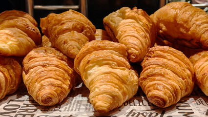 Close-up of freshly baked croissants arranged in a display, showcasing their golden crispy layers and flaky texture