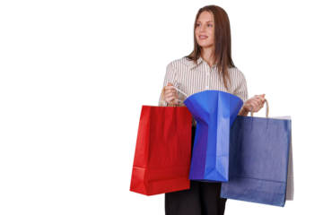 Happy woman holding multiple colorful shopping bags, enjoying consumerism and sales, studio shot with transparent background