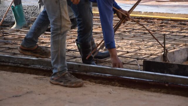 Construction workers pour concrete floors, Concrete pouring during commercial floor construction faceless workers coordinating defocused, Construction workers pouring concrete over metal grid with cem