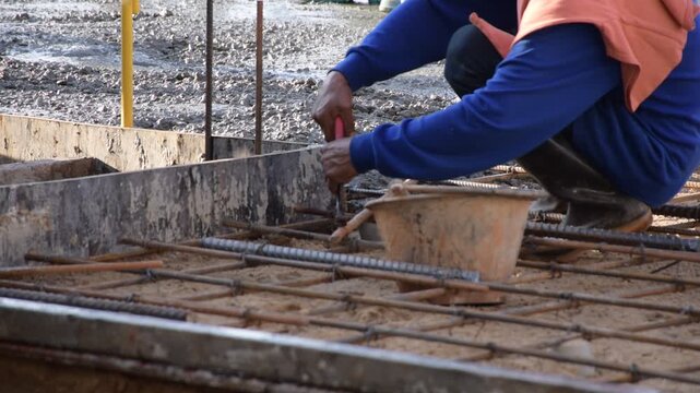 Construction workers pour concrete floors, Concrete pouring during commercial floor construction faceless workers coordinating defocused, Construction workers pouring concrete over metal grid with cem