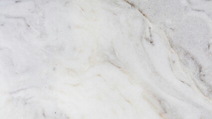 Close up shot of a white marble surface with subtle gray and beige veining pattern throughout the stone