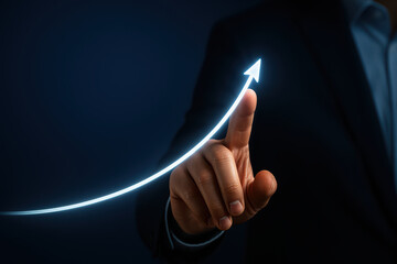 Businessman pointing at glowing upward arrow symbolizing growth and success, representing progress and achievement in dark background with confident mood