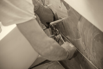 Obraz premium Plumber installs a toilet in a new bathroom. Moving to a new house concept