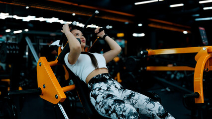 A woman is performing a seated chest press exercise on a machine
