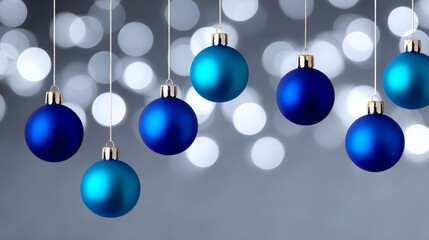 Blue Christmas ornaments hanging on silver strings, with a blurred bokeh background of shimmering lights, creating a festive and joyful holiday atmosphere for seasonal celebrations