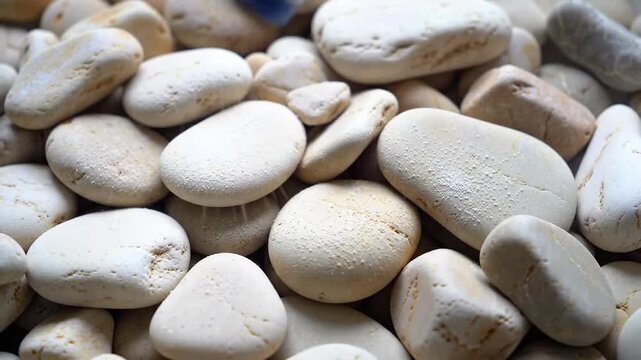 Close up of smooth white and tan river stones filling the frame
