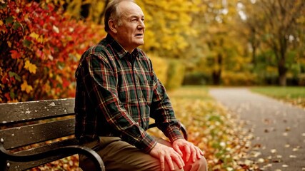 contemplative elderly man sitting on a park bench during autumn surrounded by vibrant fall foliage capturing reflective moments of solitude and