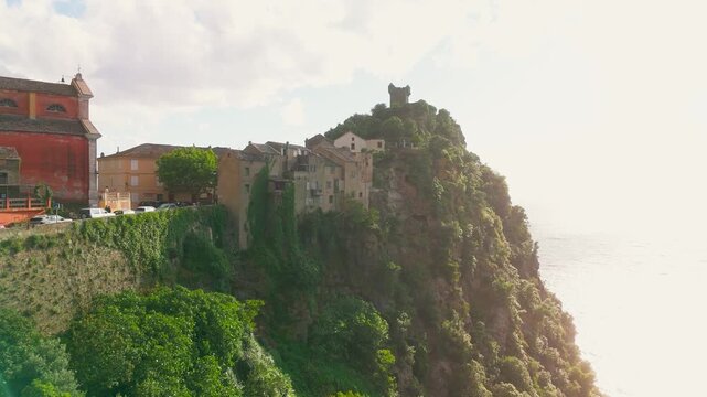 Smooth Aerial Drone Ascent Over the Colorful Nonza Village and Historic Paoline Tower Ruins Perched on Steep Cliffs Above the Mediterranean Sea, Cap Corse, Corsica, France.