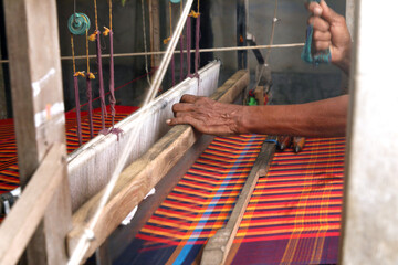 Man weaving Saree  on a traditional wooden handloom in tamilnadu
