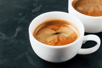 A Close-Up View of Freshly Brewed Espresso in White Cups on a Dark Surface, Highlighting the Rich Aroma and Creamy Texture for Coffee Lovers Everywhere