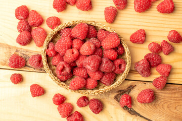 Sweet raspberries on a wooden table, close-up, top view.