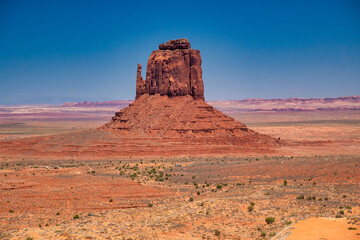 Scenic Monument Valley with iconic red rock formations and arid terrain during summer season