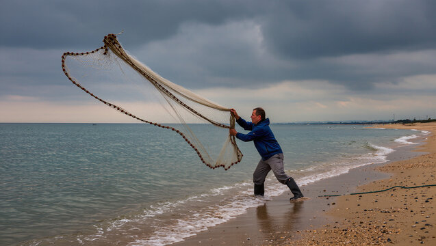 pescatore lancia la rete dalla spiaggia