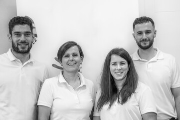 Obraz premium Four friendly Caucasian physiotherapists standing together in a healthcare facility