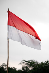 Symbol of Freedom, Indonesian Flag Flying High on Bamboo Pole Under the Sky