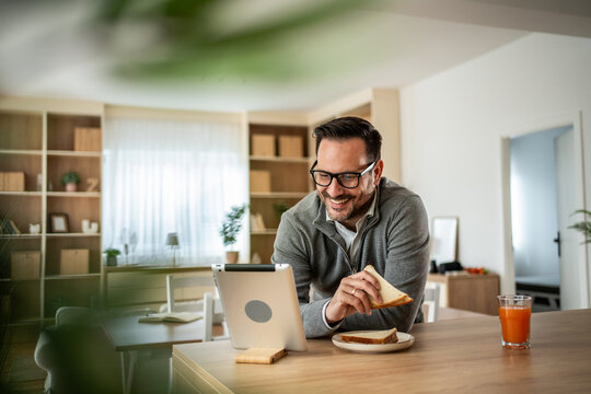 Man enjoying breakfast during online video call at home