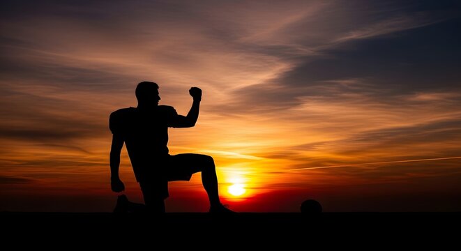 Silhouette of Victorious Man Celebrating Success Against a Dramatic Sunset Sky