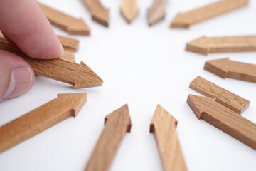 Arrangement of Wooden Arrows Directed Inward with a Hand Placing One in the Circle on White Background Directional Sign Wood Design