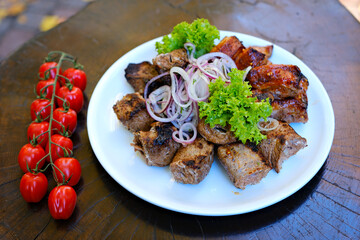 Juicy barbecue pork ribs and dry chicken wings with glaze, beer snacks lie on a wooden tray. High quality photo