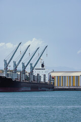 Fototapeta premium Cargo ship loading at commercial port in Aviles