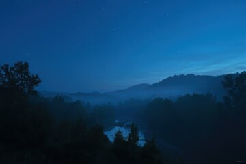 Naklejka premium Serene Nocturne: A captivating nightscape unfolds, revealing a tranquil mountain landscape shrouded in mist under a starlit sky.