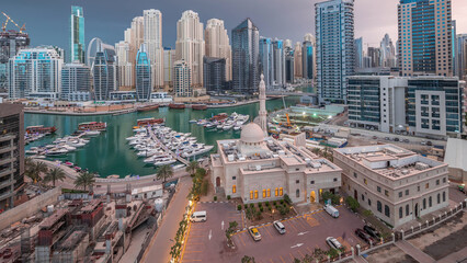 Yachts in Dubai Marina flanked by the Al Rahim Mosque and residential towers and skyscrapers aerial...